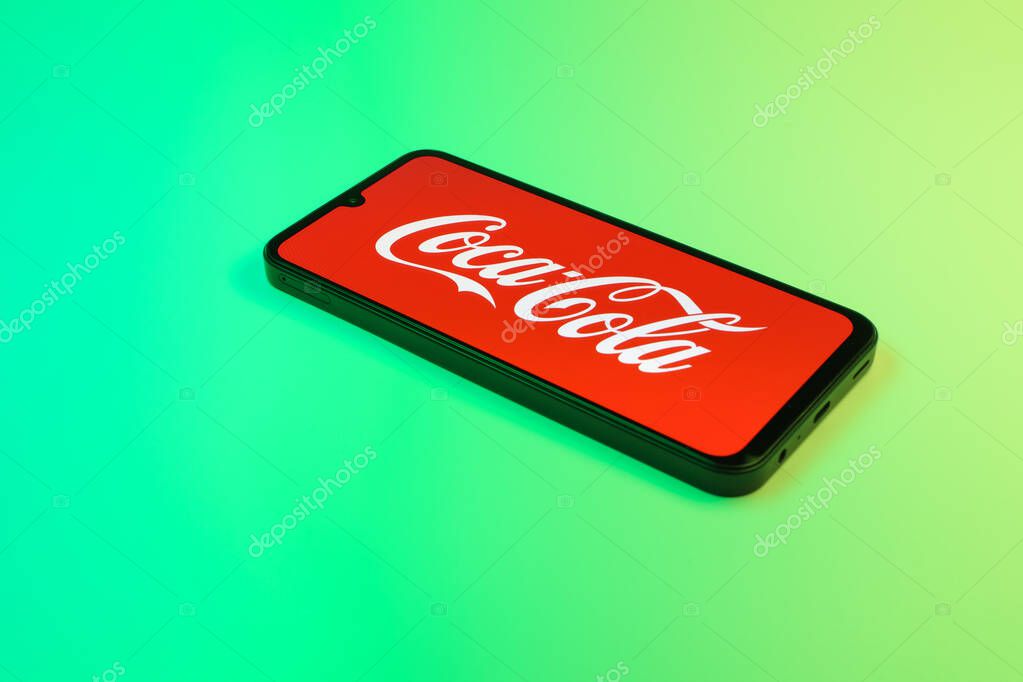 Prague, Czechia - 10 21 2024: Smartphone on surface showing Coca-Cola logo.