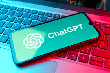 Prag, Çek Cumhuriyeti - 21 Ekim 2024: Laptop klavye arkaplanındaki modern akıllı telefon aygıtı GPT logosunu gösteriyor.