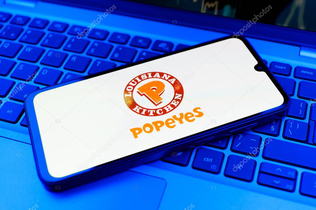 Prague, Czechia - 10 21 2024: Smartphone on surface showing Popeyes logo.