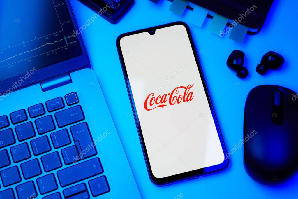 Prague, Czechia - 10 21 2024: Smartphone on surface showing Coca-Cola logo.