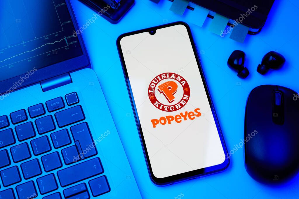 Prague, Czechia - 10 21 2024: Smartphone on surface showing Popeyes logo.
