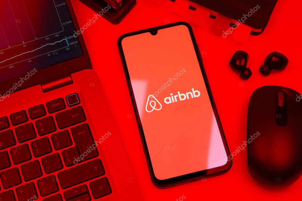 Prague, Czechia - 10 21 2024: Smartphone on surface showing Airbnb logo.