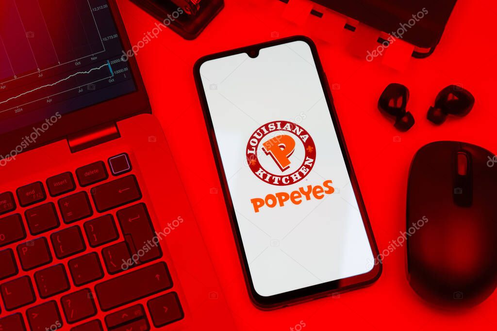 Prague, Czechia - 10 21 2024: Smartphone on surface showing Popeyes logo.