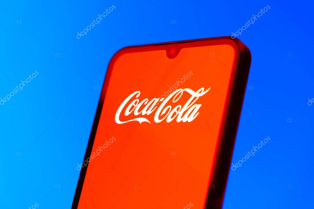 Prague, Czechia - 10 21 2024: Smartphone on surface showing Coca-Cola logo.
