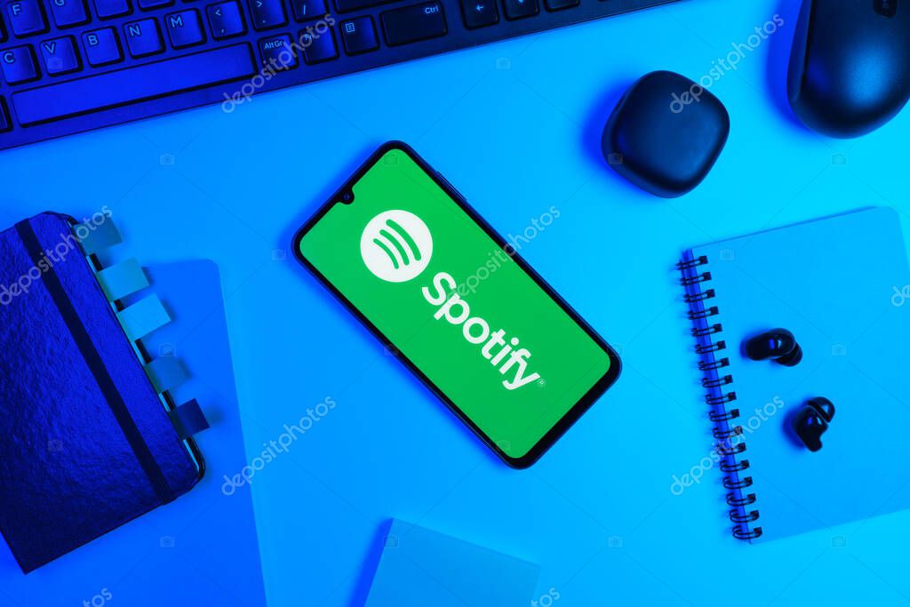 Prague, Czechia - 10 21 2024: Smartphone on surface showing Spotify logo.