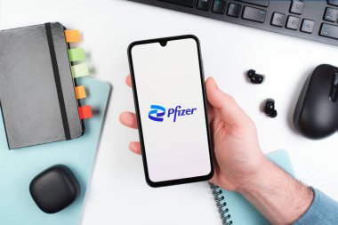 Prag, Çek Cumhuriyeti - 10 21 2024: Yüzeyde Pfizer logosu gösteren akıllı telefon.