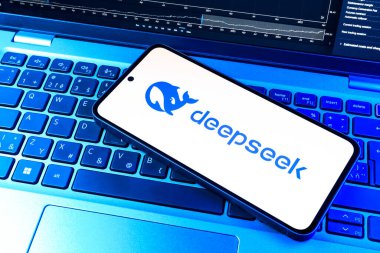 Prag, Çek Cumhuriyeti - 12 Ocak 2025: Laptop klavye arka planında DeepSeek logosunu gösteren akıllı telefon.