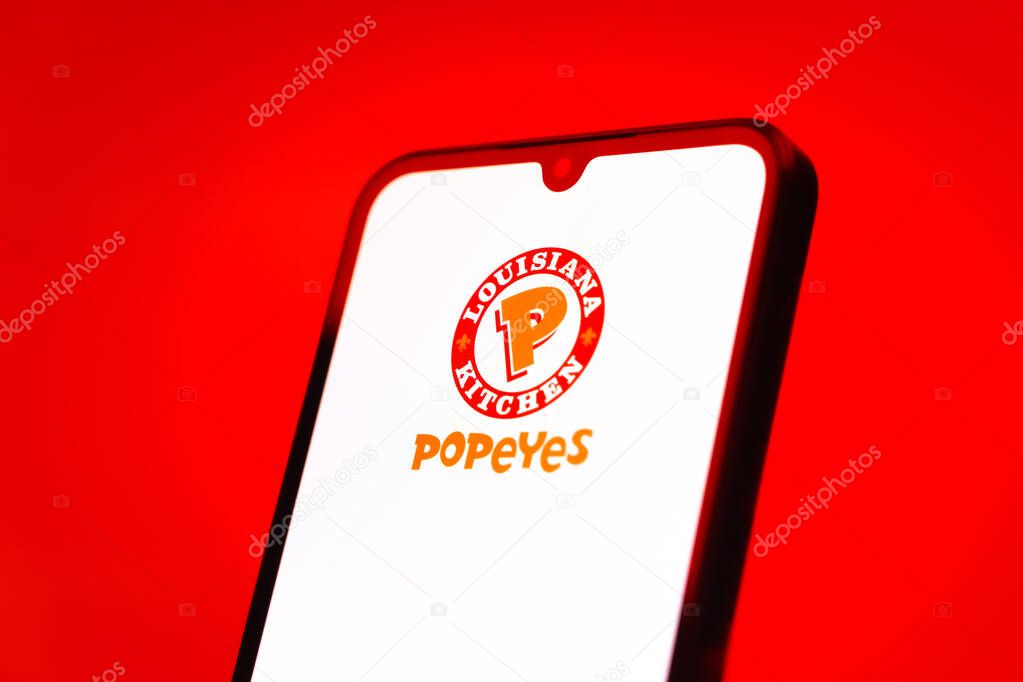 Prague, Czechia - 10 21 2024: Smartphone on surface showing Popeyes logo.