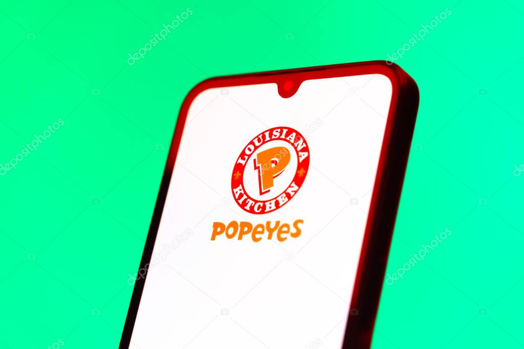 Prague, Czechia - 10 21 2024: Smartphone on surface showing Popeyes logo.
