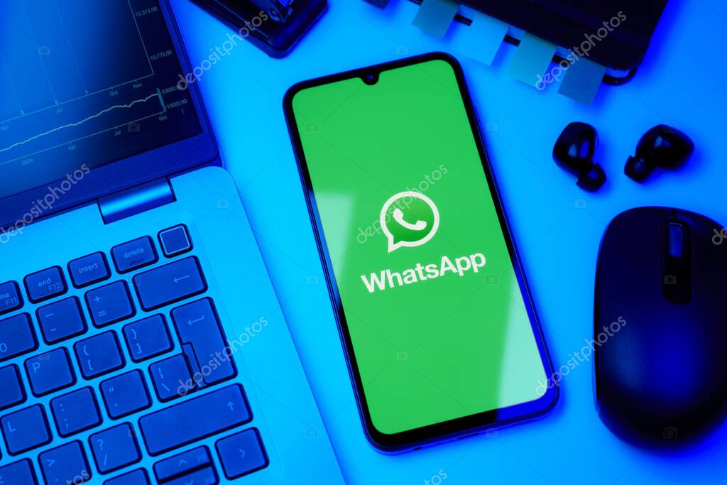 Prague, Czechia - 10 21 2024: Smartphone on surface showing WhatsApp logo.