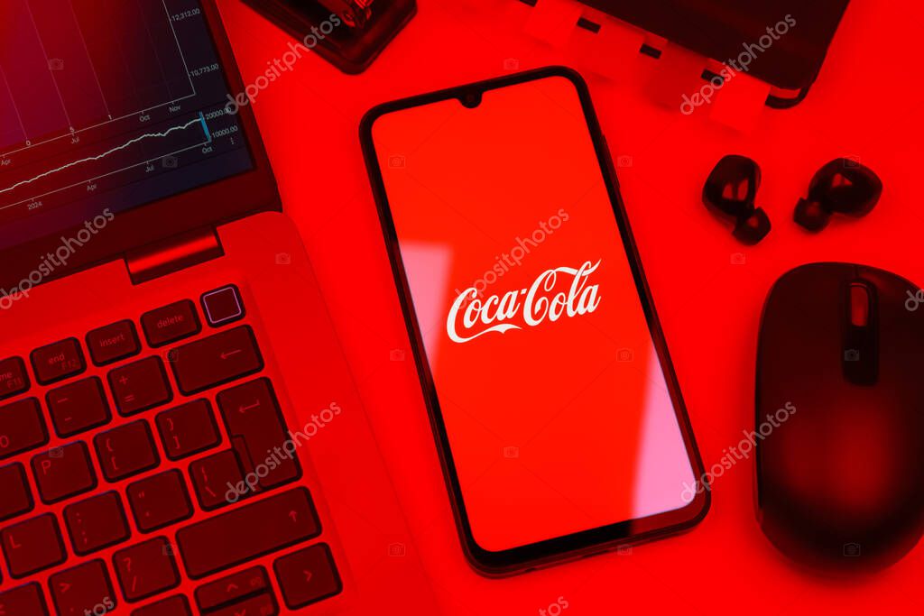 Prague, Czechia - 10 21 2024: Smartphone on surface showing Coca-Cola logo.
