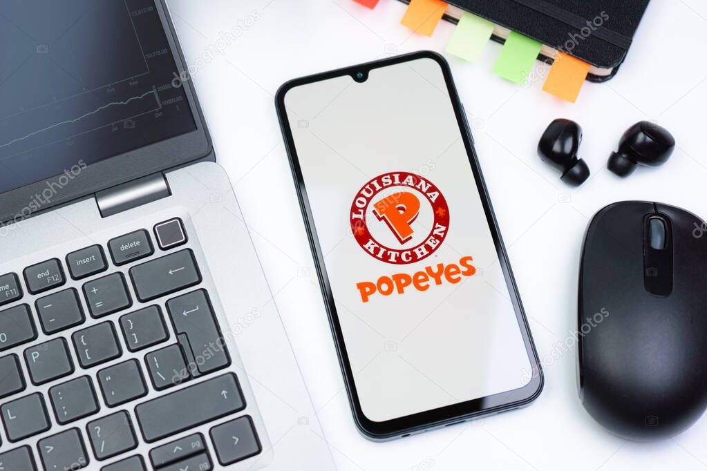 Prague, Czechia - 10 21 2024: Smartphone on surface showing Popeyes logo.