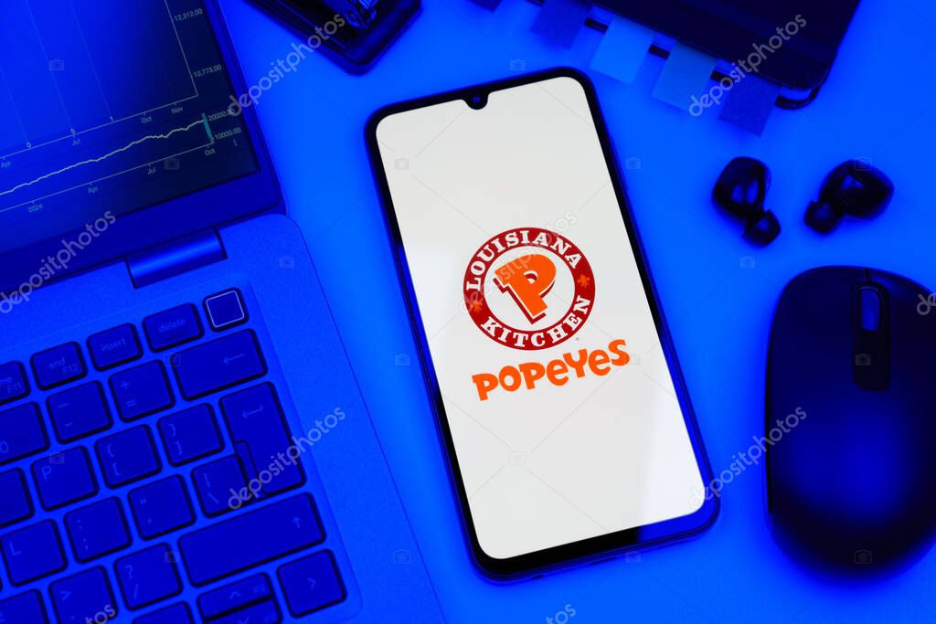 Prague, Czechia - 10 21 2024: Smartphone on surface showing Popeyes logo.