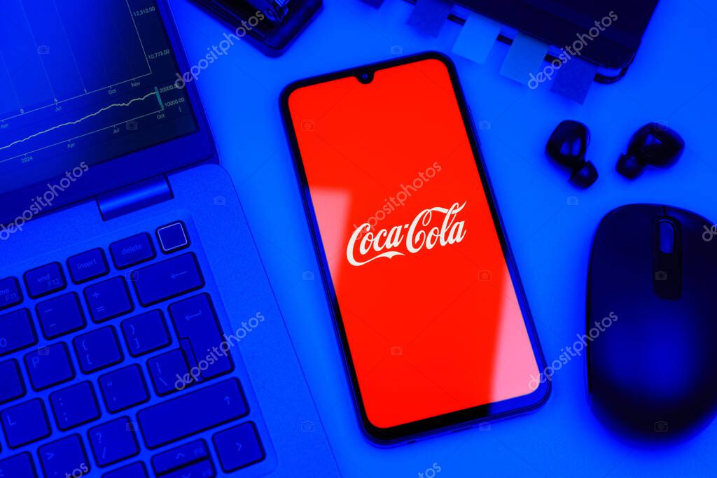 Prague, Czechia - 10 21 2024: Smartphone on surface showing Coca-Cola logo.