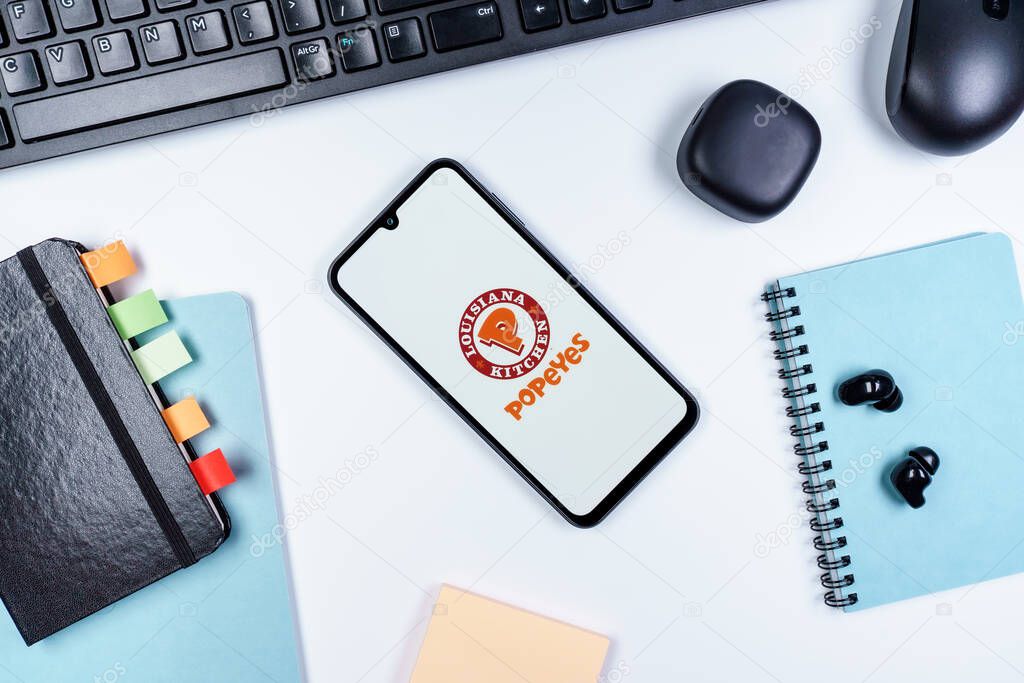 Prague, Czechia - 10 21 2024: Smartphone on surface showing Popeyes logo.