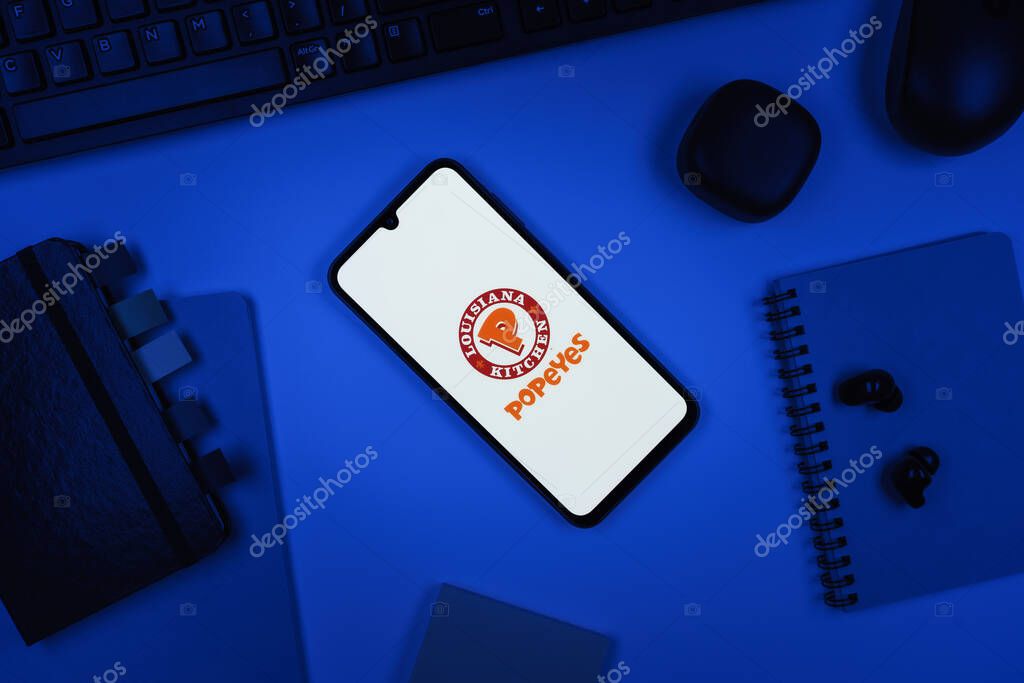Prague, Czechia - 10 21 2024: Smartphone on surface showing Popeyes logo.