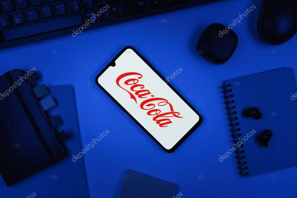 Prague, Czechia - 10 21 2024: Smartphone on surface showing Coca-Cola logo.