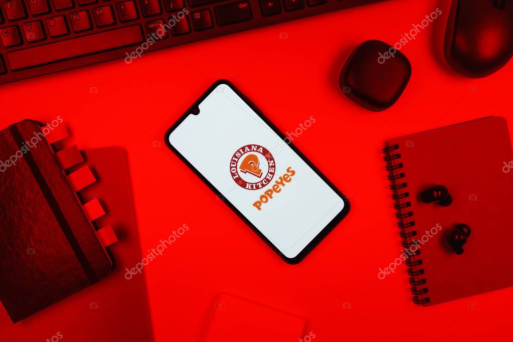Prague, Czechia - 10 21 2024: Smartphone on surface showing Popeyes logo.