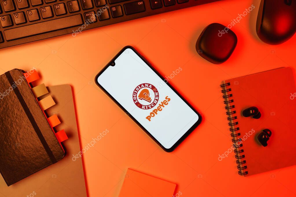 Prague, Czechia - 10 21 2024: Smartphone on surface showing Popeyes logo.