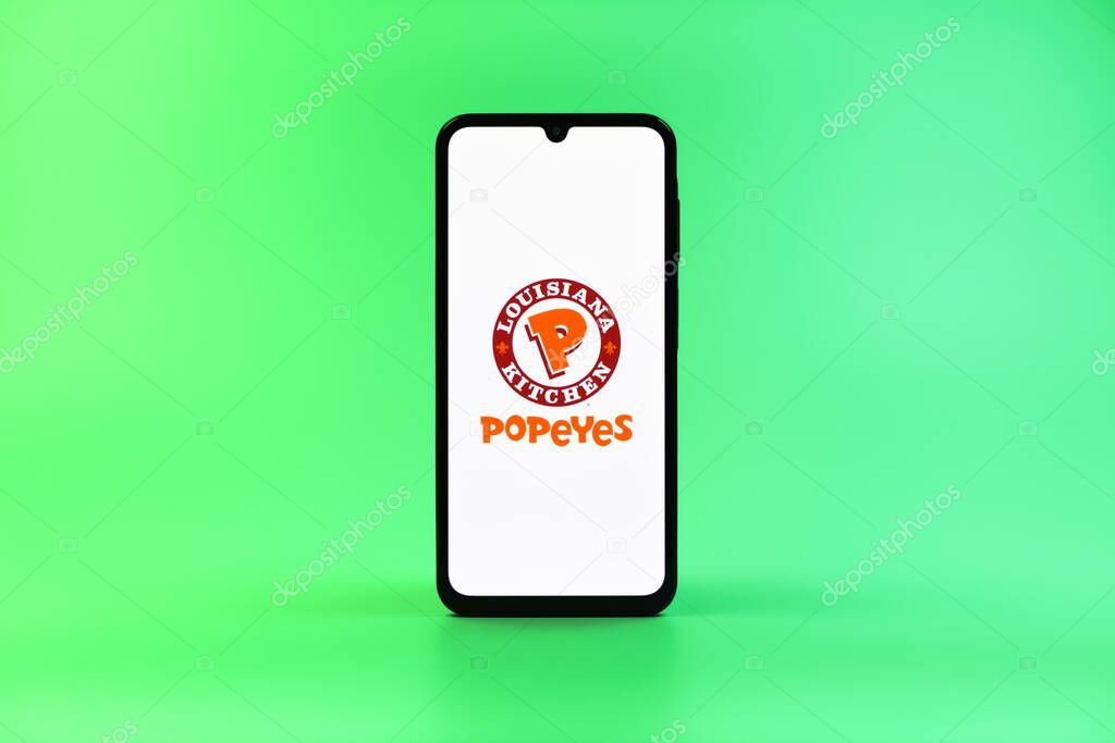 Prague, Czechia - 10 21 2024: Smartphone on surface showing Popeyes logo.
