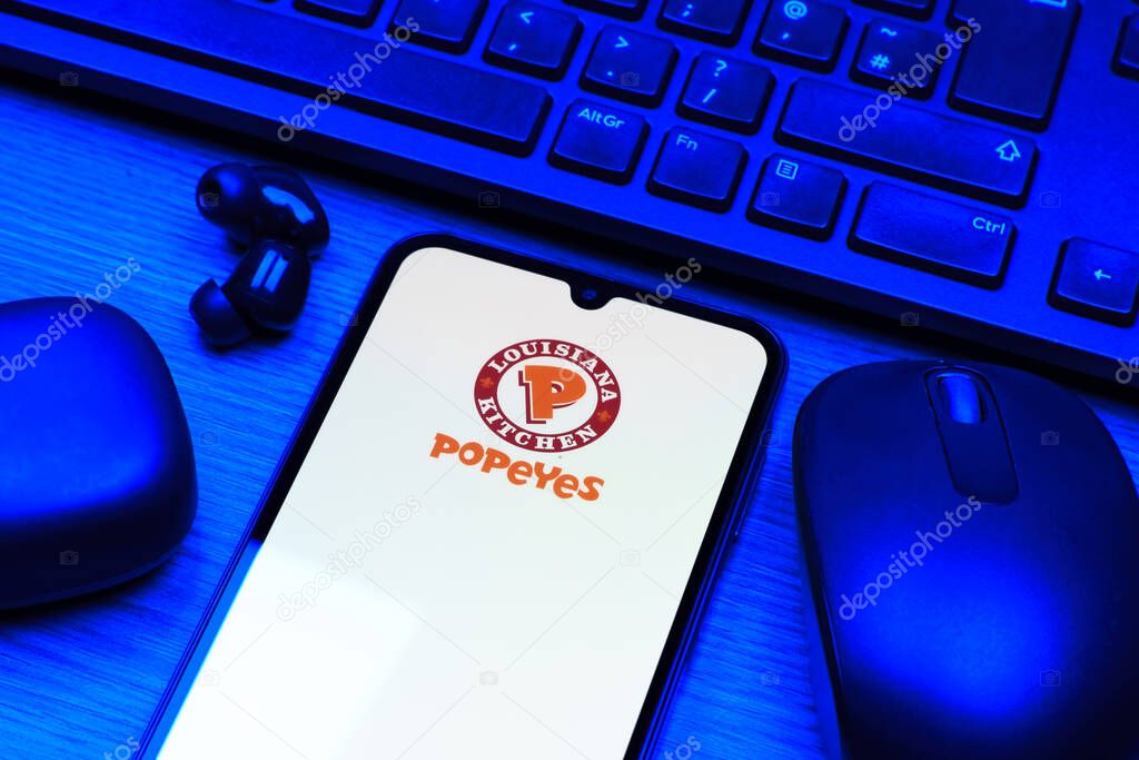 Prague, Czechia - 10 21 2024: Smartphone on surface showing Popeyes logo.