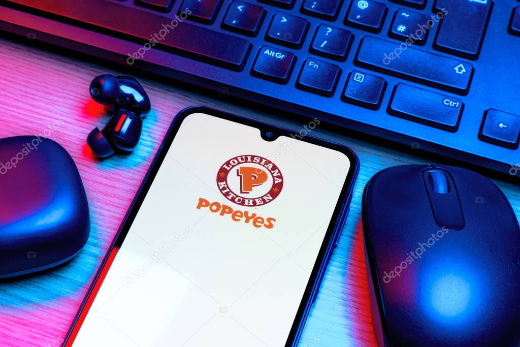 Prague, Czechia - 10 21 2024: Smartphone on surface showing Popeyes logo.