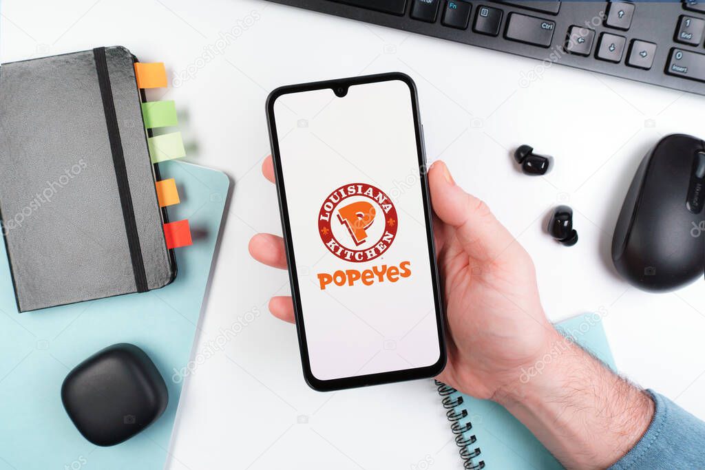 Prague, Czechia - 10 21 2024: Smartphone on surface showing Popeyes logo.