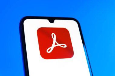 Prag, Çek Cumhuriyeti - 10 21 2024: Yüzeyde Acrobat Reader logosu gösteren akıllı telefon.