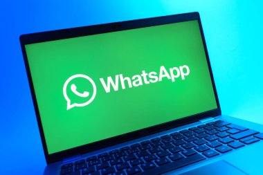 Prag, Çek Cumhuriyeti - 05 08 2025: Renkli bir arkaplanda uzanan dizüstü bilgisayarın yakın görüntüsü WhatsApp logosunu gösteriyor.