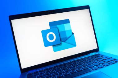 Prag, Çek Cumhuriyeti - 05 08 2025: Renkli arkaplanda uzanan ve Outlook logosunu gösteren bir dizüstü bilgisayarın yakından görüntüsü.