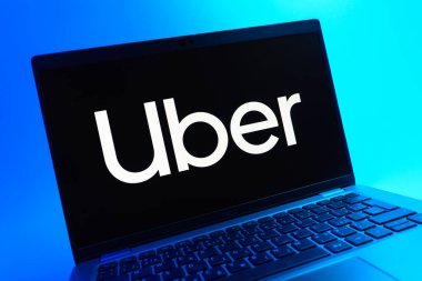 Prag, Çek Cumhuriyeti - 05 08 2025: Renkli bir arkaplanda uzanan ve Uber logosunu gösteren bir dizüstü bilgisayarın yakından görüntüsü.