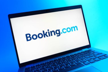 Prag, Çek Cumhuriyeti - 05 08 2025: Renkli bir arkaplanda uzanan ve Booking.com logosunu gösteren bir dizüstü bilgisayarın yakından görüntüsü.