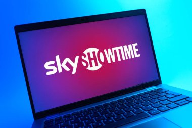 Prag, Çek Cumhuriyeti - 05 08 2025: Renkli bir arkaplanda uzanan ve SkyShowtime logosunu gösteren bir dizüstü bilgisayarın yakından görüntüsü.