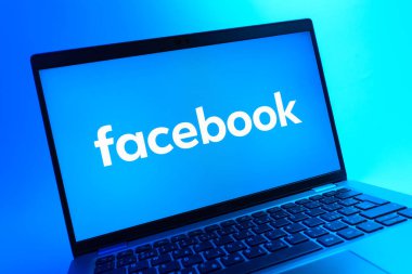 Prag, Çek Cumhuriyeti - 05 08 2025: Renkli bir arkaplanda uzanan ve Facebook logosunu gösteren bir dizüstü bilgisayarın yakından görüntüsü.