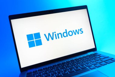 Prag, Çek Cumhuriyeti - 05 08 2025: Renkli bir arkaplanda uzanan ve Windows logosunu gösteren bir dizüstü bilgisayarın yakından görüntüsü.
