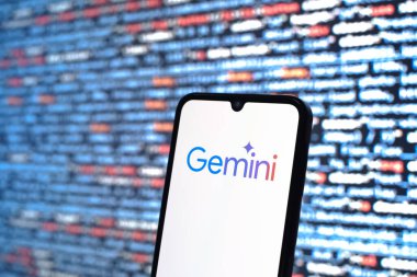 Prag, Çek Cumhuriyeti - 05: 18 2025: Kaynak kod arkaplanının önündeki akıllı telefon Gemini logosunu gösterir.