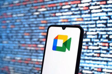 Prag, Çek Cumhuriyeti - 05: 18 2025: Kaynak kod arkaplanı önündeki bir akıllı telefon Google Meet logosunu görüntüler.