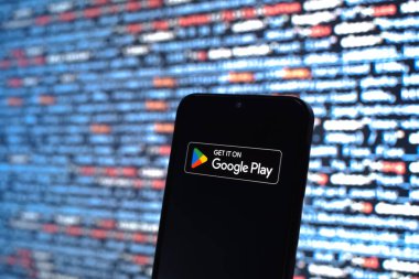 Prag, Çek Cumhuriyeti - 05: 18 2025: Kaynak kod arkaplanı önündeki bir akıllı telefon Google Play logosunu görüntüler.