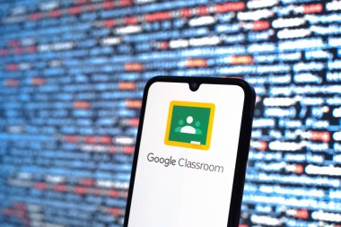 Prag, Çek Cumhuriyeti - 05: 18 2025: Kaynak kod arkaplanı önündeki bir akıllı telefon Google Sınıfı logosunu görüntüler.