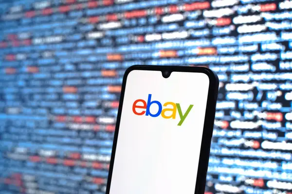 Prag, Çek Cumhuriyeti - 05: 18 2025: Kaynak kod arkaplanı önündeki bir akıllı telefon eBay logosunu görüntüler.