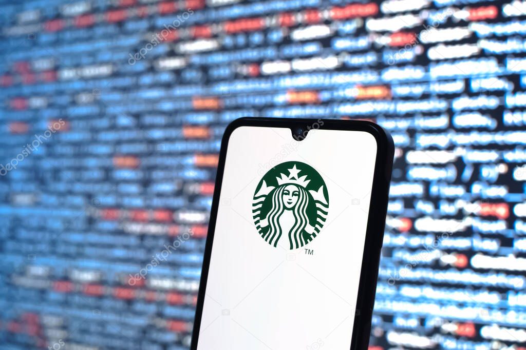 Prague, Czechia - 05 18 2025: A smartphone in front of source code background displays Starbucks logo.