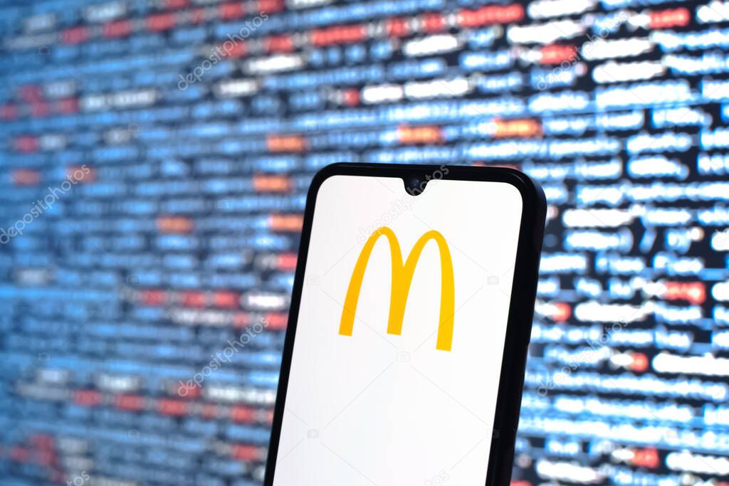 Prague, Czechia - 05 18 2025: A smartphone in front of source code background displays McDonalds logo.