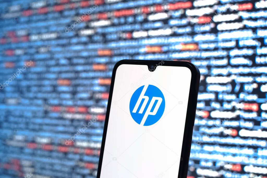 Prague, Czechia - 05 18 2025: A smartphone in front of source code background displays Hewlett-Packard logo.