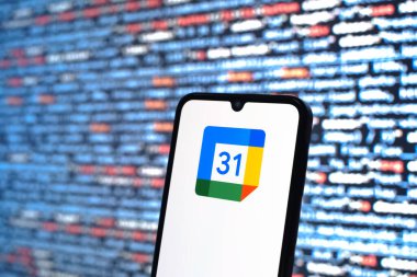 Prag, Çek Cumhuriyeti - 05: 18 2025: Kaynak kod arkaplanı önündeki bir akıllı telefon Google Takvim logosunu görüntüler.