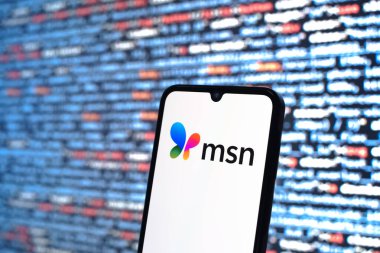 Prag, Çek Cumhuriyeti - 05: 18 2025: Kaynak kod arkaplanı önündeki bir akıllı telefon MSN logosunu görüntüler.