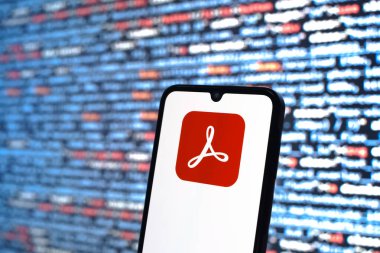 Prag, Çek Cumhuriyeti - 05: 18 2025: Kaynak kod arkaplanı önündeki bir akıllı telefon Acrobat Reader logosunu görüntüler.