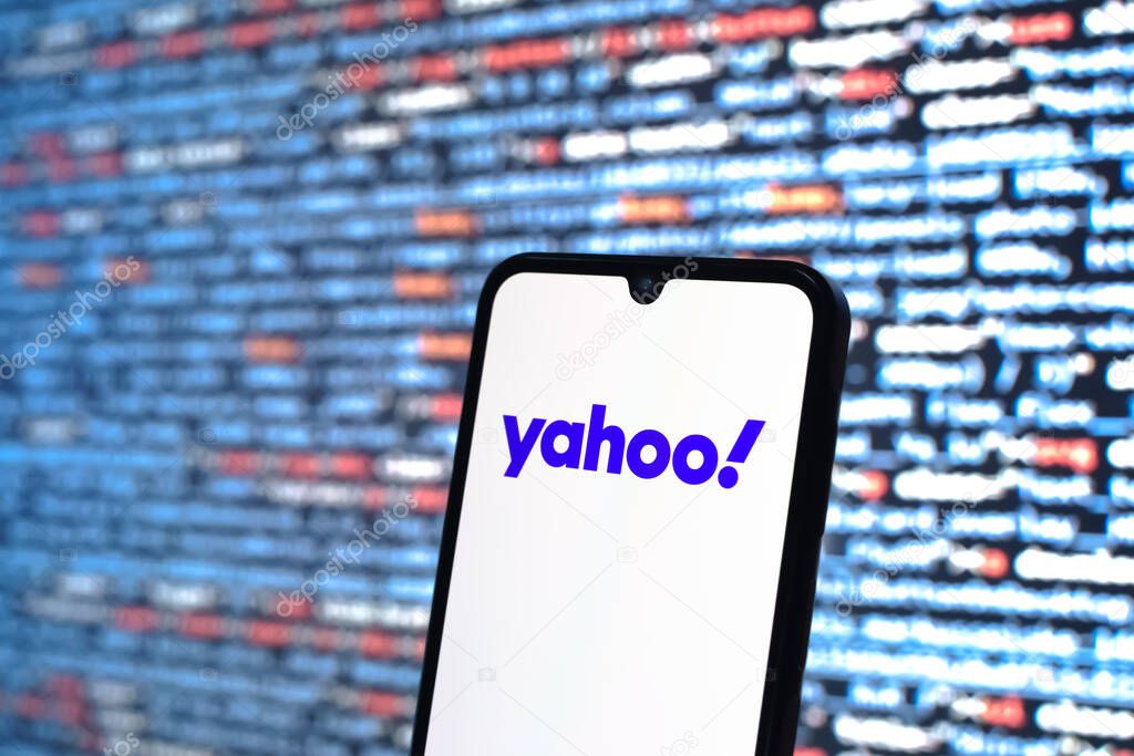 Prague, Czechia - 05 18 2025: A smartphone in front of source code background displays Yahoo logo.