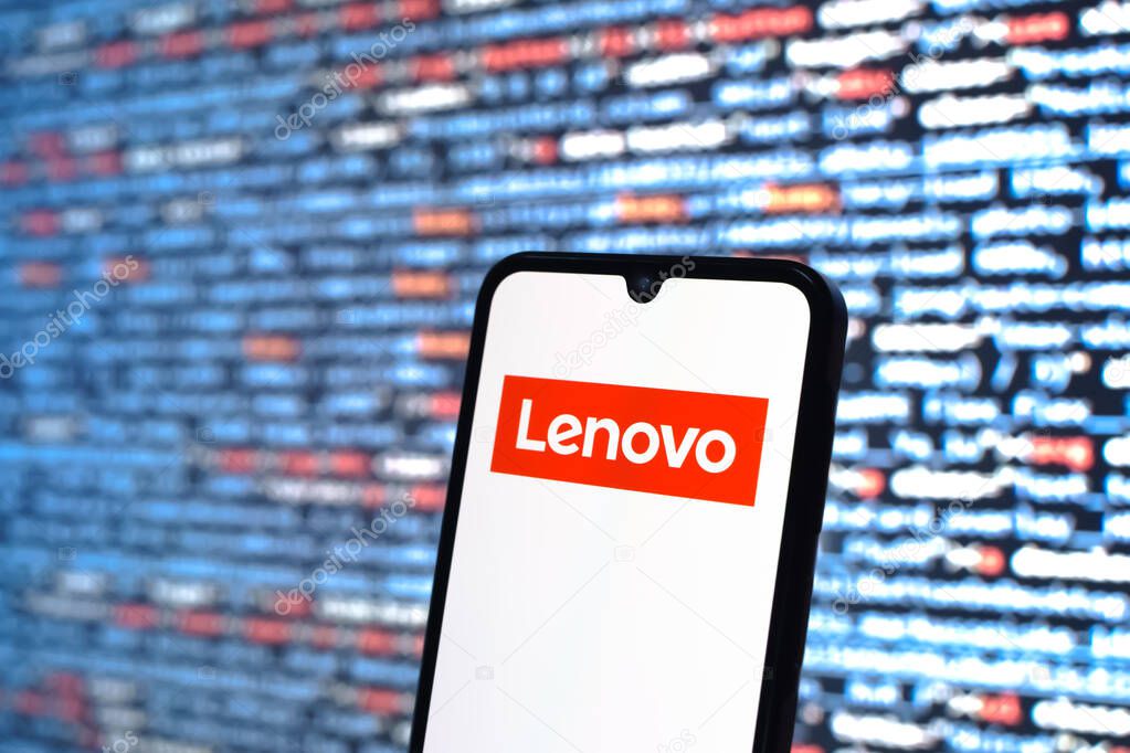 Prague, Czechia - 05 18 2025: A smartphone in front of source code background displays Lenovo logo.