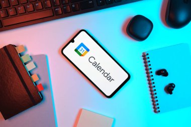 Prag, Çek Cumhuriyeti - 05: 18 2025: Google Takvim logosunu gösteren bir telefonla ofis masasına yerleştirilmiş nesneler.