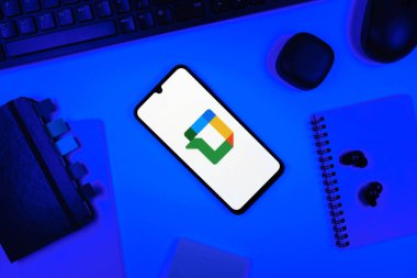 Prag, Çek Cumhuriyeti - 05: 18 2025: Google Chat logosunu gösteren bir telefonla ofis masasına yerleştirilmiş nesneler.